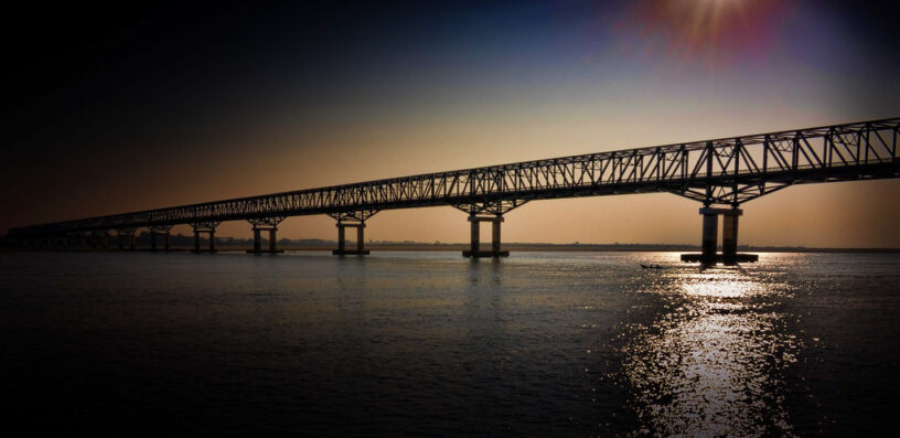Photo of a bridge spanning a river at sundown