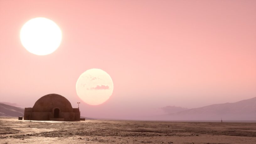 Desertscape of Tatooine, with two suns set against a pink sky, hut in the foreground on the left side of the image.