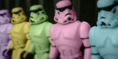 Image of five toy Stormtroopers in a line. The Storm Troopers are in different pastel colors (left to right): purple, yellow, green, pink, and blue.