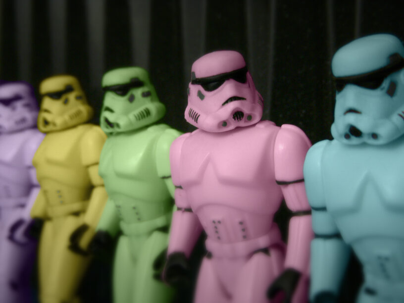 Image of five toy Stormtroopers in a line. The Storm Troopers are in different pastel colors (left to right): purple, yellow, green, pink, and blue.